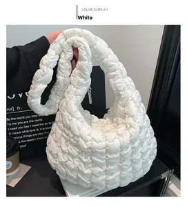 Detail of white quilted cloud bag with textured pleats and soft padded handle