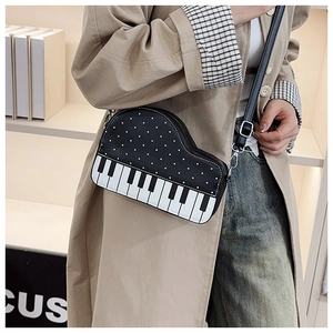 Detail shot of the piano key design and polka dot texture on a small crossbody bag