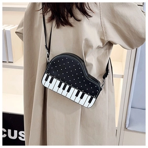 Detail of artistic piano key crossbody bag featuring polka dots and classic shoulder strap