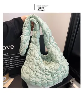 Detail of mint green quilted cloud bag featuring soft pleated texture and handle