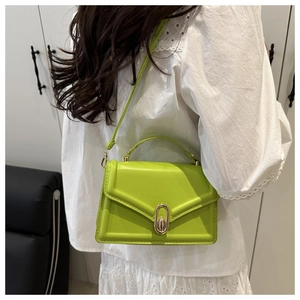 Detail of neon green leather crossbody bag featuring a golden oval metal buckle