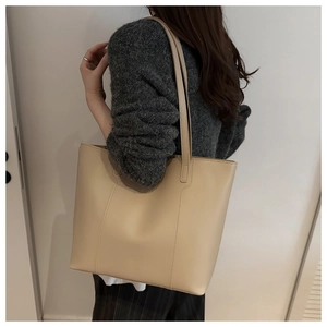 Close-up of beige tote bag showing long shoulder straps and smooth leather texture