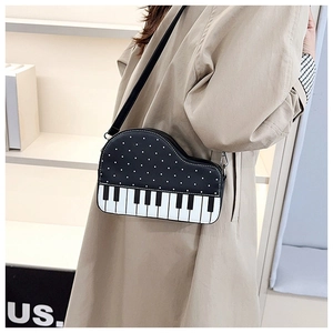 Detail showing piano keyboard print on a black crossbody bag with polka dots design