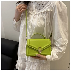 Close-up of lime green crossbody mini bag featuring a gold oval clasp and top handle
