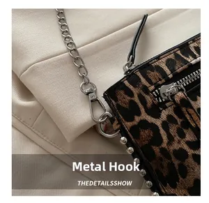 Detailed macro view of silver metal hardware hook and chain on leopard print bag