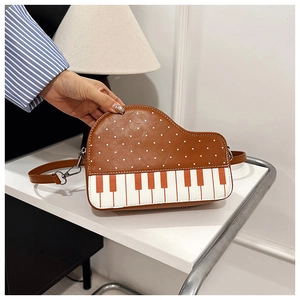 Detail view of piano-style crossbody bag with polka dots and keyboard pattern design