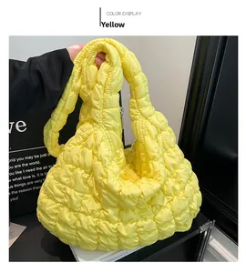 Detail of a bright yellow quilted cloud bag showing soft padded pleated texture