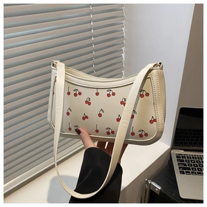 Detail view of white leather shoulder bag with cherry print and silver chain link