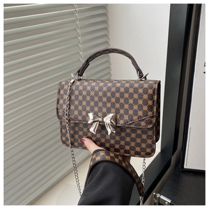 Detailed view of dark brown geometric monogram mini square bag with silver bow buckle