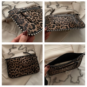 Detailoverzicht van luipaardprint crossbodytas met zilveren ketting en studs op de bodem