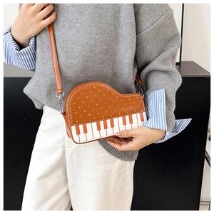 Detail showing creative piano shaped crossbody bag with polka dot pattern and piano keys