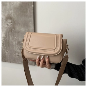 Detail of apricot leather saddle bag with U-shaped embossing and wide strap