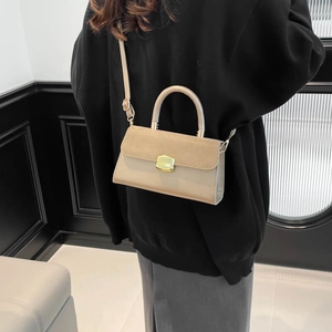 Fashion beige crossbody handbag with suede texture and gold buckle on black hoodie model