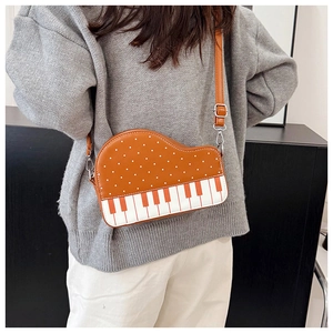 Detail view of creative piano-shaped crossbody bag with polka dots and adjustable strap