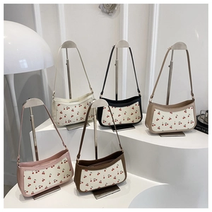 Detailed display of assorted color cherry print baguette bags on a display stand