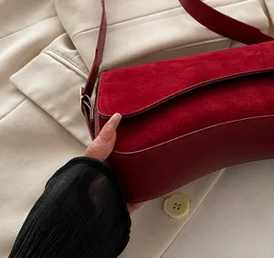 Detail showing deep red suede texture and smooth leather with neat stitching