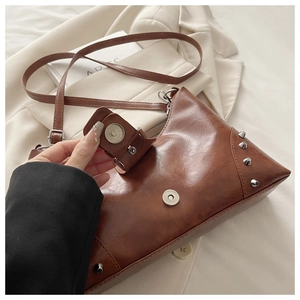 Detail showing the magnetic closure and silver stud accents on a brown vintage handbag