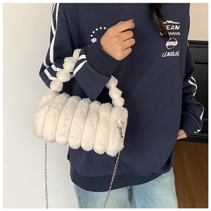 Détails d'un sac à main en fausse fourrure blanche avec texture côtelée et chaîne