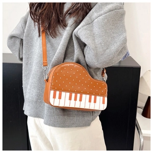 Detail view of piano-style crossbody bag with white dots and musical keyboard pattern
