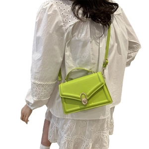 Neon green textured leather mini crossbody bag with golden oval buckle and top handle