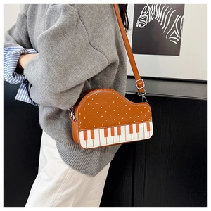 Detail of creative piano-shaped crossbody bag with brown polka dot leather and piano keys