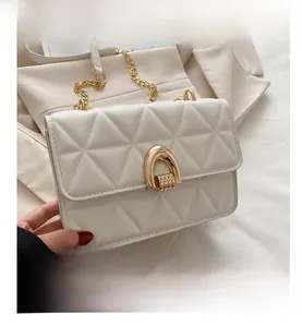 Detail of white quilted handbag featuring gold horseshoe twist-lock and chain strap