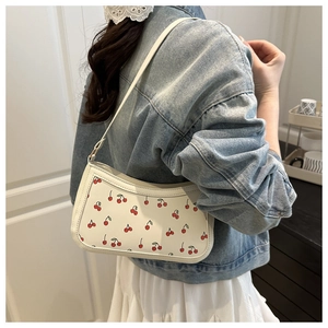 Detail of white PU underarm bag featuring vibrant cherry print and sleek chain strap