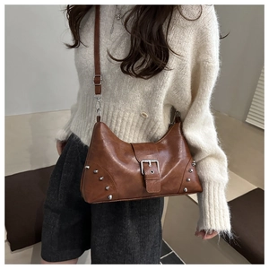 Detail of vintage brown shoulder bag with silver buckle and studs on textured PU leather