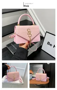 Pink crossbody bag with woven texture lid, gold S-logo, and elegant tassel charm detail