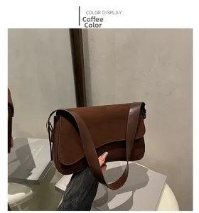 Detailed view of coffee-colored suede shoulder bag featuring a unique curved flap design