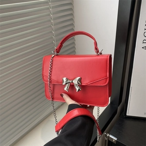 Red square leather bag with silver bow accent and metal chain strap for women