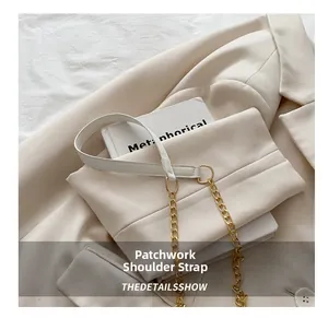 Detail view of stylish beige chain strap with leather and gold metal on shoulder bag