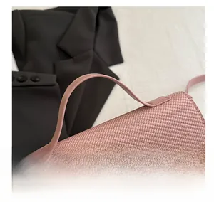 Détail du sac à main rose tissé avec poignée lisse et boucle en métal argenté