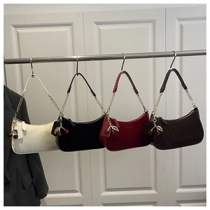 Détail de quatre sacs hobo avec chaînes dorées et breloques cerise en diverses couleurs