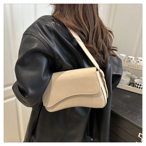 Detail of off-white crossbody saddle bag with asymmetrical wave flap and wide strap