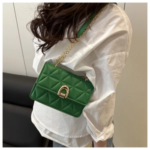 Detail of green quilted crossbody bag featuring a gold chain strap and metal clasp lock
