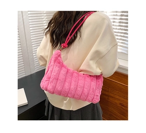 Gros plan détaillé du sac en peluche rose avec texture côtelée et sangle à nœud élégante
