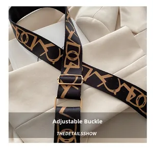 Detail of adjustable black woven shoulder strap with geometric pattern and gold buckle
