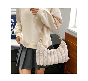 Gros plan du sac à main en peluche crème avec texture rayée verticale et bandoulière en cuir