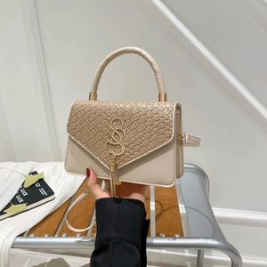 Elegant off-white woven shoulder bag with gold letter charm and tassel accent