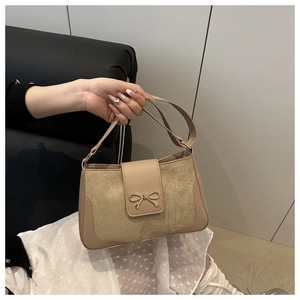 Detailed close-up of a khaki crossbody bag with a golden bow buckle and smooth leather finish