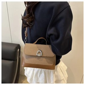 Détail d'un sac besace en patchwork avec tissage beige et cuir marron élégant