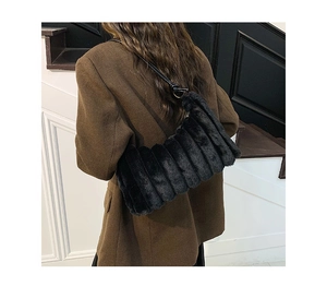 Détail du sac à bandoulière en fausse fourrure noire avec texture pelucheuse rayée