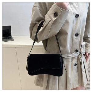 Minimalist black flap shoulder bag in suede texture styled with a beige trench coat
