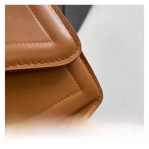 Close-up of tan leather handbag showing fine stitching and quilted texture detail