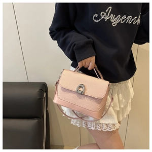 Détail du mélange cuir lisse et texture tissée rose avec fermoir fer à cheval argenté
