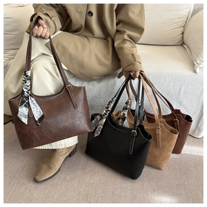 Detail of four faux leather tote bags in coffee, black, brown and red with silk scarves