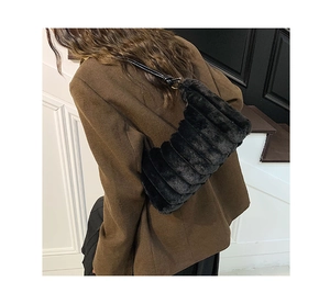 Détail du sac à épaule en fausse fourrure noire avec texture côtelée sur un mannequin