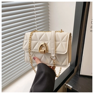 Close-up of white quilted chain bag with gold arch buckle and diamond stitching texture