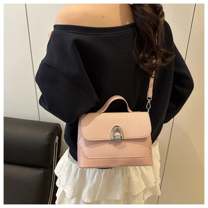 Détail du sac bandoulière rose montrant le contraste tissé et le fermoir à boucle